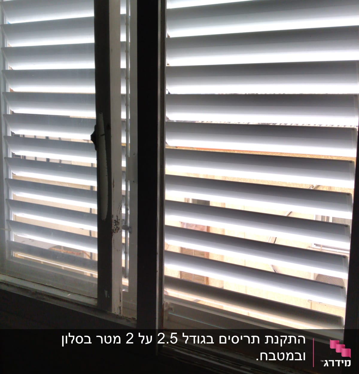 תריסי אלומיניום לבנים על חלון זכוכית